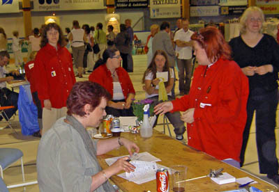 Monica, Lena och Tina i röda assistentrockar. Malin sitter med på ett hörn